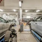 Interior bengkel otomotif dengan kendaraan yang sedang dalam proses servis dan perawatan